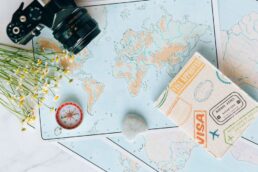 Dettaglio di mappa con macchina fotografica, bussola e passaporto, simboli di viaggio e pianificazione vacanze