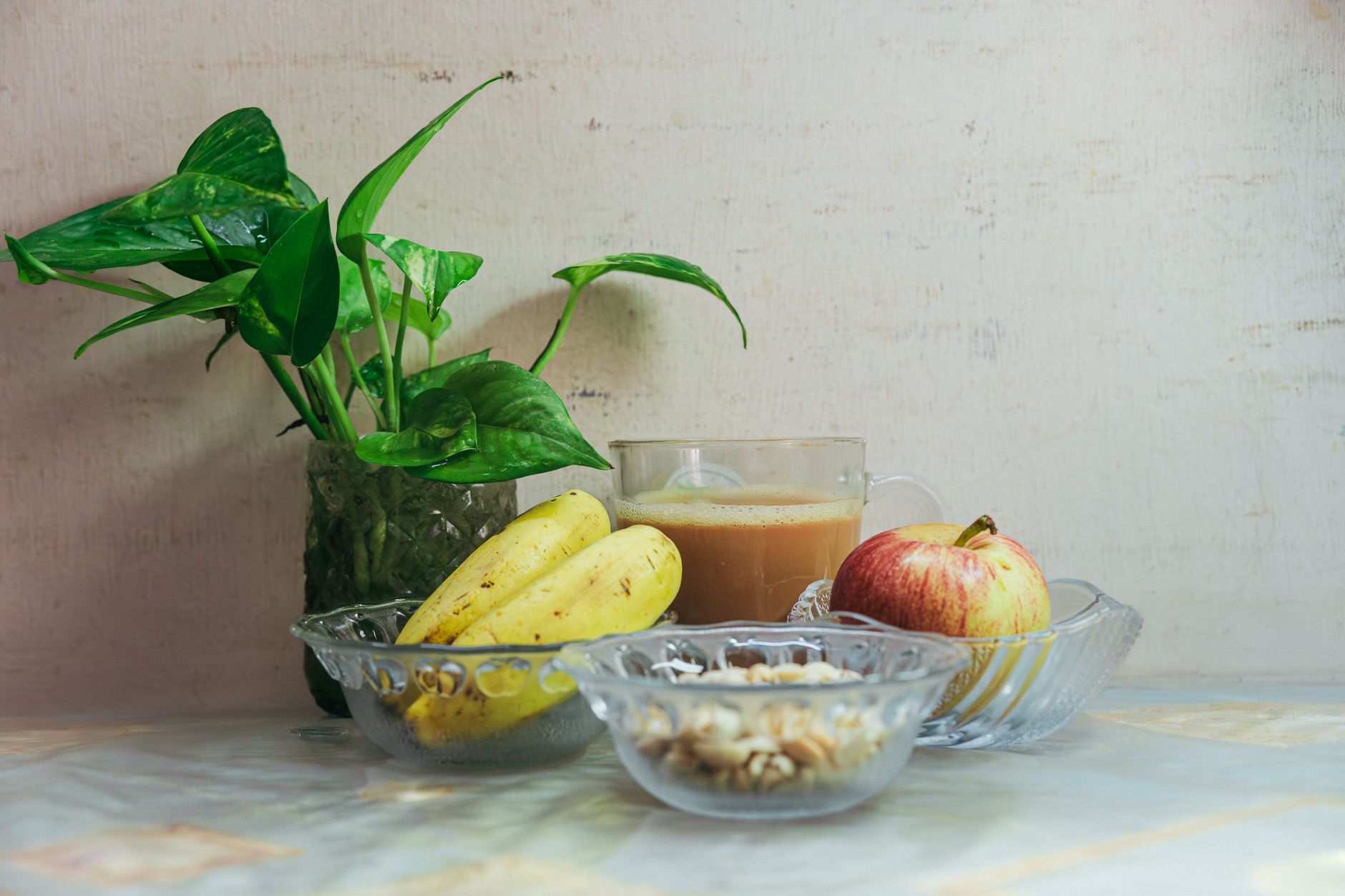 Colazione sana con frutta, cereali e bevanda in vetro su tavolo chiaro