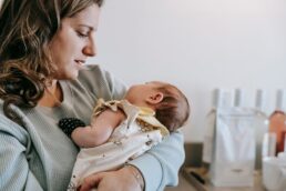 Mamma che tiene in braccio neonato in un ambiente domestico