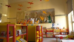 Sala di lettura per bambini con scaffali colorati pieni di libri illustrati