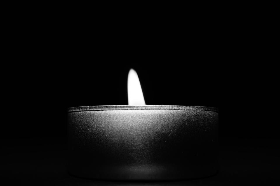 Candela accesa in bianco e nero, simbolo di lutto e memoria