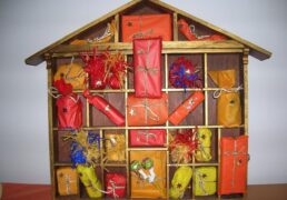 Calendario dell'Avvento in legno a forma di casetta con 24 pacchetti