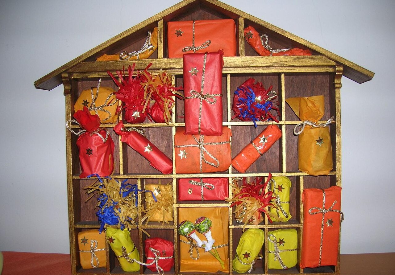 Calendario dell'Avvento in legno a forma di casetta con 24 pacchetti