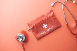 Primo piano di un kit di pronto soccorso e stetoscopio su sfondo arancione