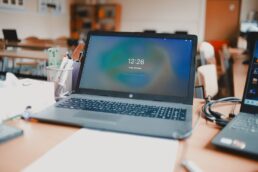 Computer portatile acceso su una scrivania in aula scolastica vuota